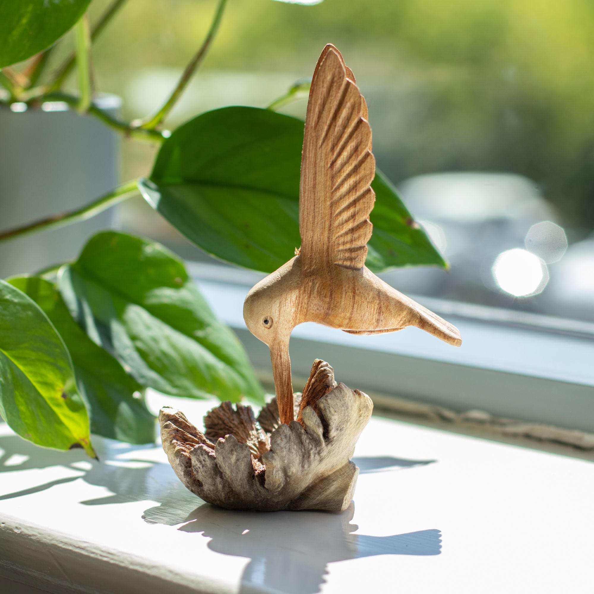 Handgefertigte Skulptur eines Kolibris, der Nektar aus einer Baumverwachsung trinkt
