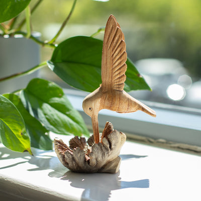 Handgefertigte Skulptur eines Kolibris, der Nektar aus einer Baumverwachsung trinkt